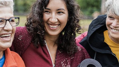 Three women smiling together.